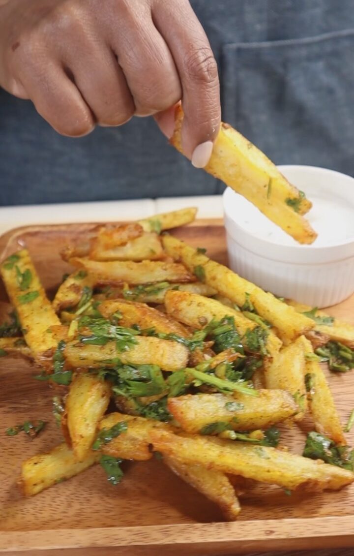 A person holding a knife over some food.
